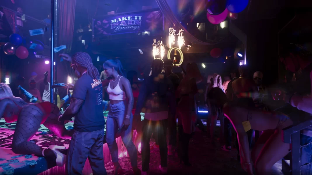 Interior de um clube noturno, com pessoas dançando ou conversando ao redor de um palco onde uma mulher dança com roupas provocantes. No canto, quase escondidos pelas sombras, uma mulher dança de forma sensual em frente a um homem. Ao fundo no alto, a área VIP com pessoas dançando.